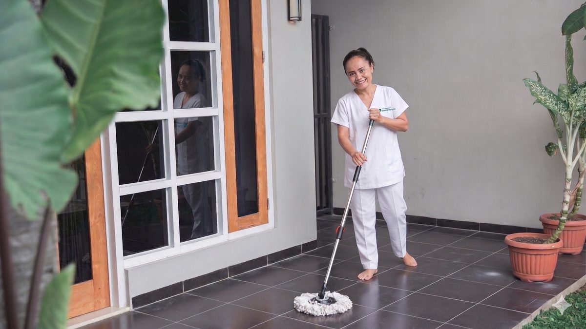 Caregiver helping elderly woman with walker